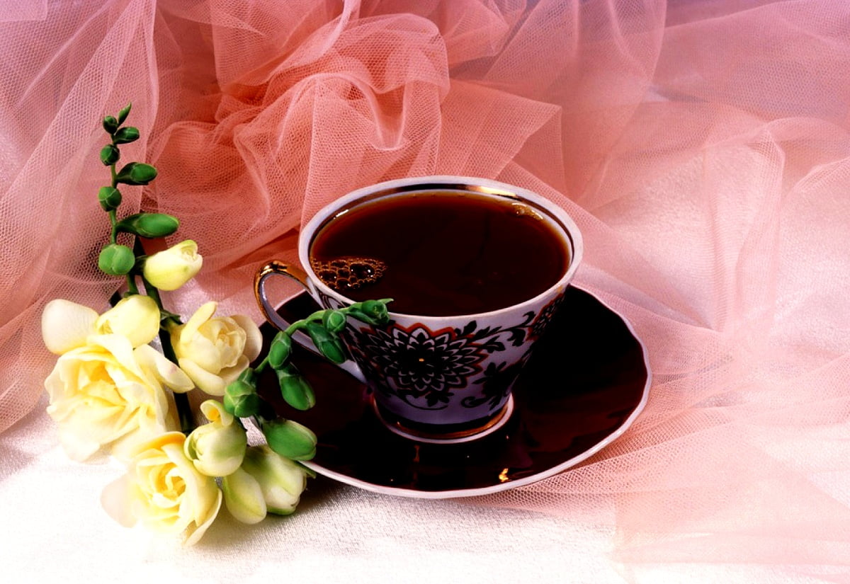 Kopp kaffe och vas med blommor på bordet / bakgrundsbild 1600x1100